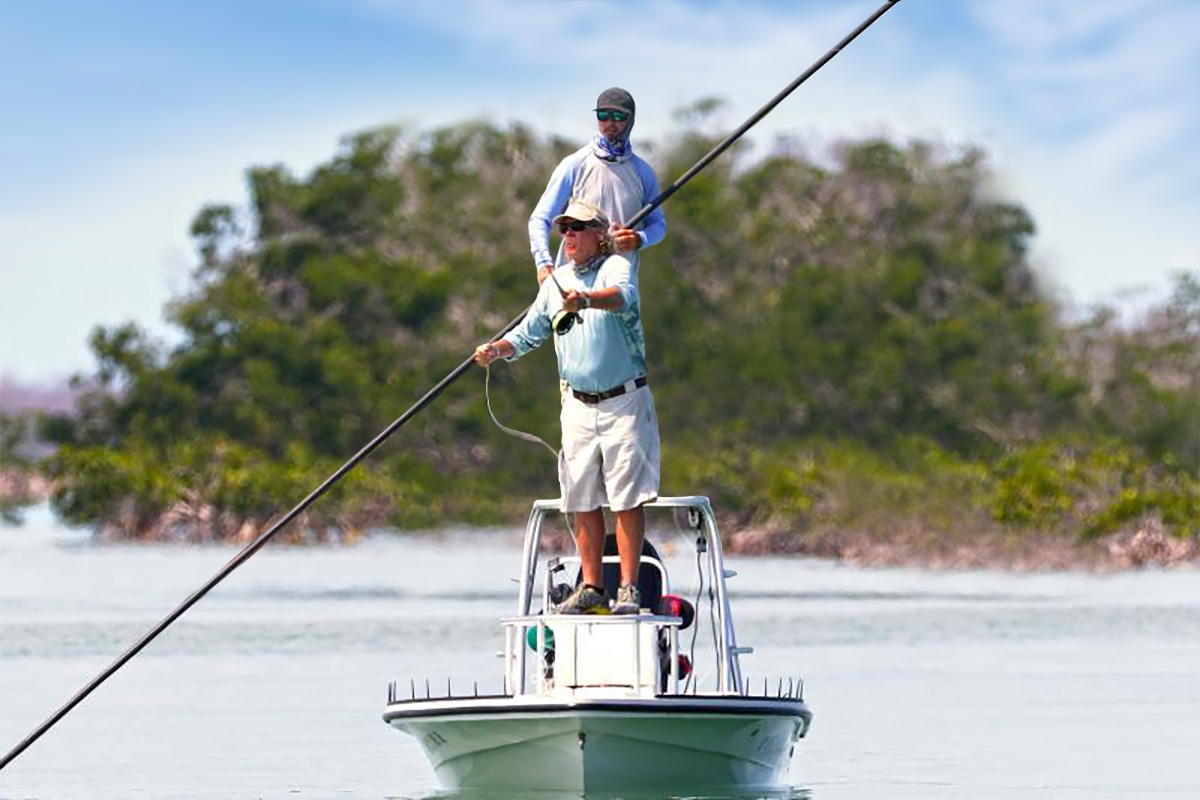 two anglers flats fishing on a pole boat