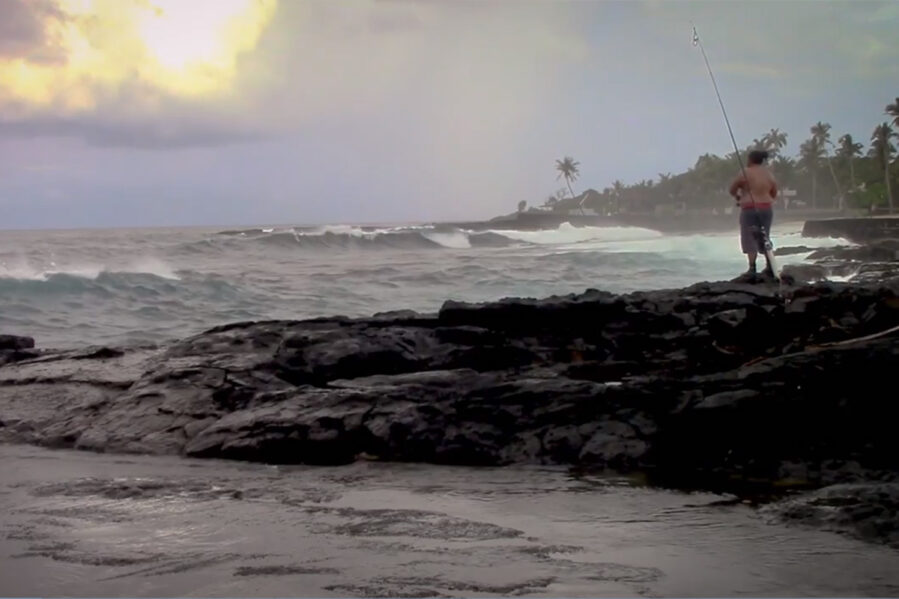 man surf fishing from the shore of american samoa islands